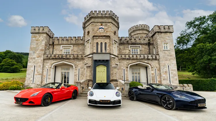 Ferrari, Porsche and Aston Martin convertibles outside an Irish castle