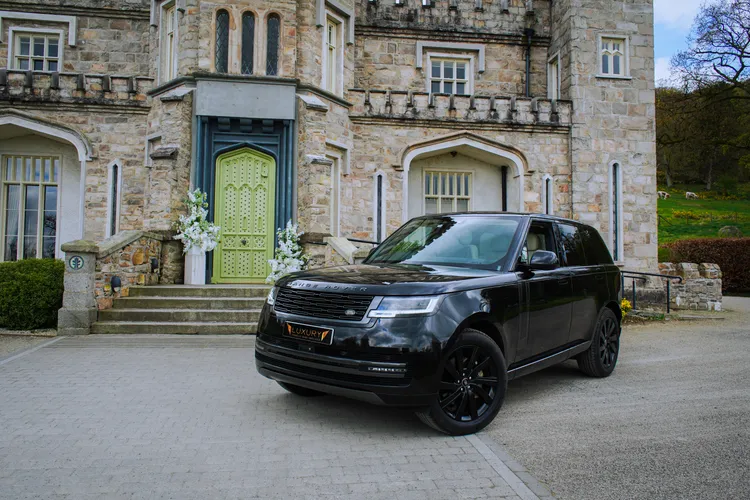 Black Range Rover parked beside castle steps in Ireland