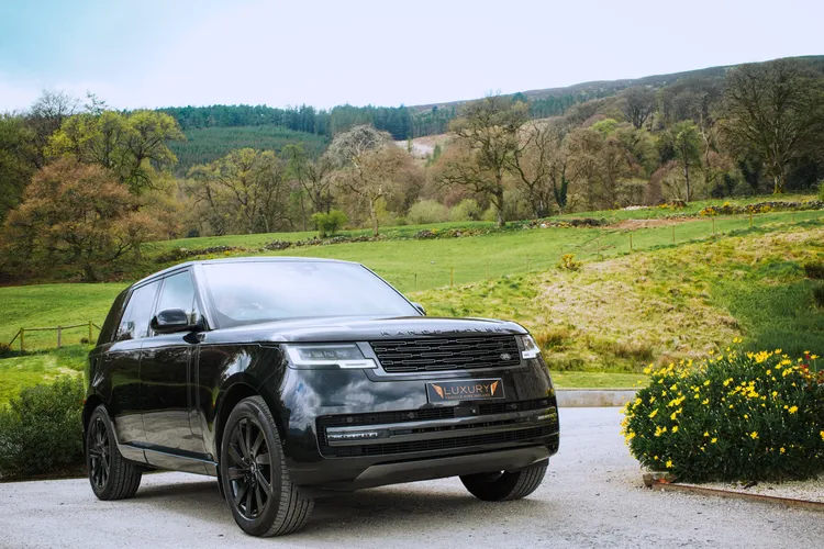 Black Range Rover with Irish countryside in the background