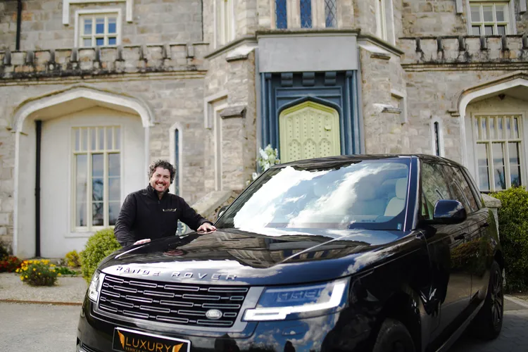 Owner of Luxury Vehicle Hire Ireland handing over a Range Rover at a country house