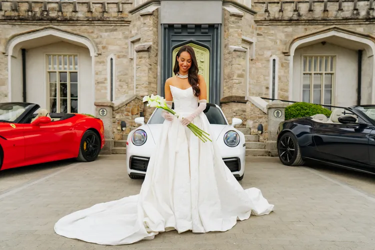 Bride beside a red Ferrari convertible on her wedding day