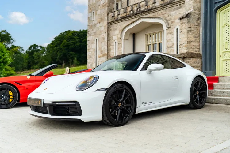White Porsche 911 Carrera on a manor house driveway